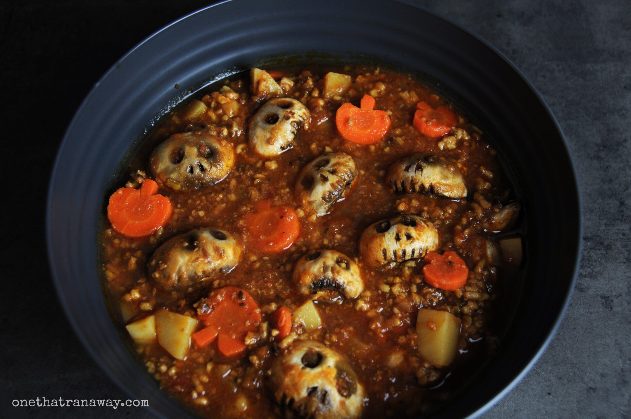 witches brew stew with skull shaped mushrooms and carrots in a dark grey bowl