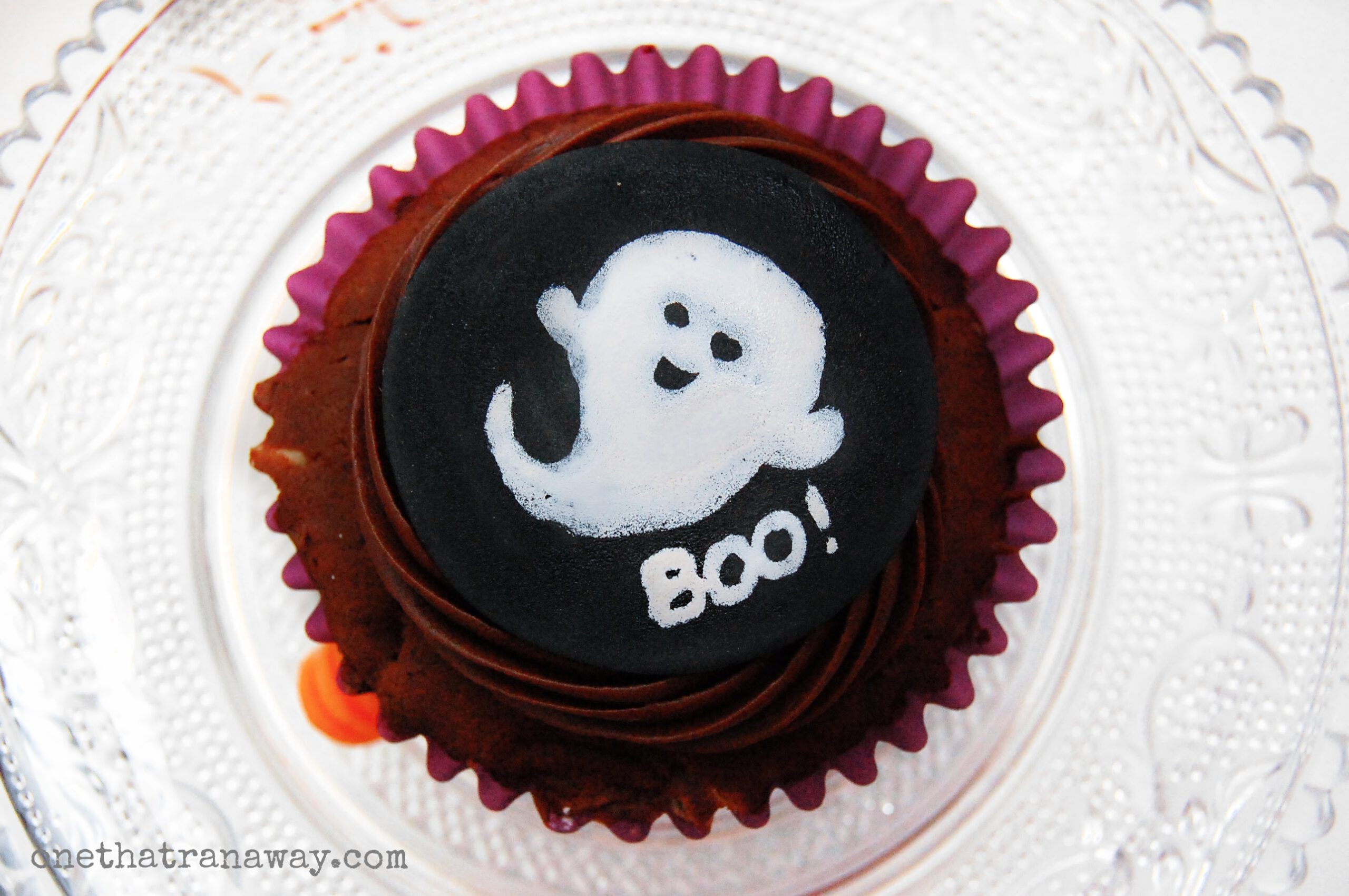 chocolate cupcake with a black fondant topper showing the silhouette of a ghost